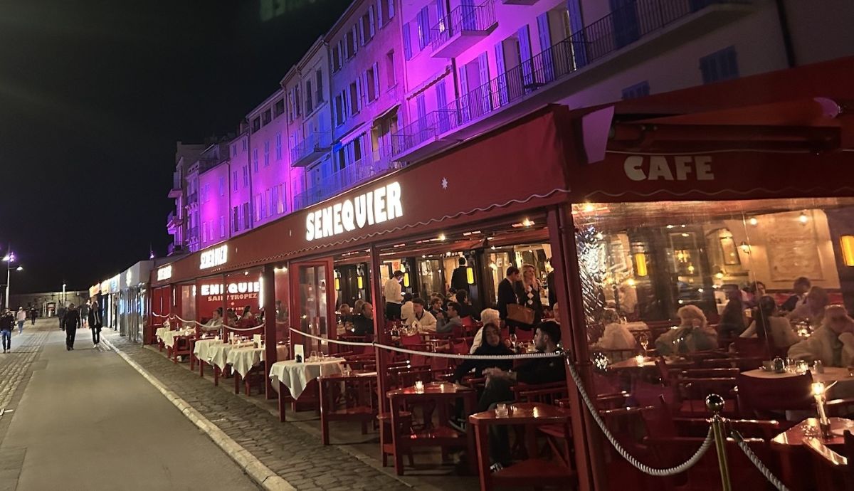In Saint Tropez, Cafe Sénéquier at night with buildings lit for Pink October. Photo Catherine Sabino